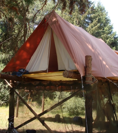 Ein einfacher Hochbau mit Zelt. Unten ist zum gemütlicherem Aufenthalt ein Tarnnetz angebracht.